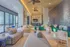 Contemporary lounge area with stylish seating, ceiling fans, and large windows offering natural light and views.
