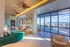 Luxurious modern lounge with artistic decor, featuring plush seating, expansive windows, and scenic outdoor views.