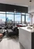 Luxurious city apartment interior featuring a stylish living room with large windows, modern couch, and chic kitchen island with marble countertop overlooking stunning urban views.