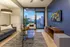 Modern living room with chic decor, featuring a cozy seating area, stylish entertainment setup, and a stunning city view through expansive windows.