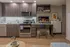 Contemporary kitchen with sleek modern cabinetry, stainless steel appliances, and a cozy workspace perfect for multitasking in a stylish apartment.