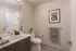 Modern bathroom with sleek vanity, elegant mirror, and vibrant artwork enhancing the neutral decor.