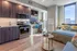 Modern studio apartment featuring an open-concept kitchen and cozy bedroom area, abundant natural light, and stylish decor with city views.