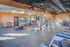 Bright and spacious gym featuring modern fitness equipment, sleek flooring, and ample natural light.