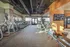 Spacious and modern fitness center with treadmills, exercise machines, and a wall-mounted TV for a dynamic workout experience.