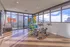 Modern and bright fitness room featuring exercise bikes and an array of colorful exercise equipment, with floor-to-ceiling windows offering stunning cityscape views.