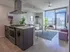 Contemporary urban apartment with a stylish kitchen island, cozy living area, and floor-to-ceiling windows offering stunning city views.