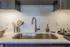 Modern kitchen with sleek quartz countertop, stylish hexagonal backsplash, and elegant stainless steel sink.