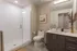 Modern bathroom with sleek vanity, glass-enclosed shower, and elegant decor, showcasing minimalist luxury.