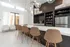 Modern kitchen with elegant pendant lighting, sleek white countertops, and stylish brown bar stools, perfect for entertaining.