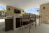 Chic outdoor entertainment area with a sleek bar counter, modern high stools, wall-mounted TV, and stylish stone accents, perfect for hosting.