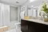 Elegant bathroom featuring sleek granite vanity, ambient lighting, and contemporary decor with fresh greenery.