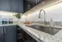 Modern kitchen with elegant granite countertops, sleek chrome faucet, and ambient under-cabinet lighting.