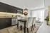 Bright and contemporary open-plan kitchen and dining area with sleek dark cabinets, elegant white curtains, and stylish decor.