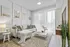 Bright and stylish living room with elegant decor, featuring a cozy sofa, chic coffee table, and modern artwork, illuminated by natural light through sheer curtains.