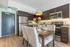 Inviting modern kitchen and dining area with elegant decor, featuring dark wood cabinets, stainless steel appliances, and a chic dining set adorned with fresh flowers.