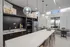Sleek modern kitchen featuring a spacious island, pendant lighting, and stainless steel appliances, opening to a bright dining area with outdoor views.