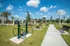 Inviting outdoor fitness area featuring modern exercise equipment, lush greenery, and clear blue skies for a refreshing workout experience.