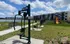 Modern apartment complex with lakeside view, outdoor gym equipment, and a vibrant playground, perfect for active living.