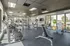 Bright and modern fitness center featuring state-of-the-art exercise equipment, large windows for natural light, and motivational wall decor.