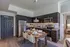 Modern kitchen featuring sleek dark cabinetry, stainless steel appliances, and a chic dining setup with elegant tableware.