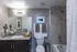Elegant bathroom with sleek granite countertop, modern fixtures, and soothing neutral tones, enhanced by chic decor and plush towels.