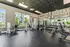 Modern fitness center with sleek equipment and motivational wall art, surrounded by large windows offering bright natural light.