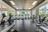 Spacious and modern fitness center with state-of-the-art equipment, large windows for natural light, and a motivating environment.