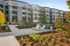 Modern apartment complex with vibrant landscaping, inviting outdoor seating area, and contemporary architectural design.