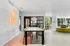 Modern dining and lounge area with sleek furniture, large dining table, vibrant wall art, and ample natural light.