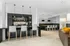 Modern open-concept dining area with sleek high stools, elegant pendant lighting, and a stylish coffee station.