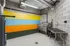 Modern apartment bike room featuring vibrant striped wall, stainless steel fixtures, and organized maintenance station.