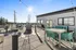 Inviting rooftop terrace with modern seating, ambient string lights, and panoramic views under a clear blue sky.