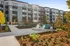 Modern apartment complex with sleek architecture, vibrant landscaping, and inviting outdoor seating areas.