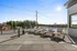 Expansive sunlit deck with stylish lounge chairs offering scenic views of lush greenery and clear blue skies.