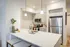 Contemporary kitchen with sleek white cabinetry, stainless steel appliances, and elegant pendant lighting over a spacious quartz countertop island.
