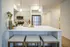 Modern kitchen with sleek stainless steel appliances, elegant pendant lighting, and a spacious island with seating for three.