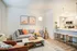Chic and inviting living space with a modern gray sofa, vibrant cushions, stylish decor, and a sleek breakfast bar, perfect for urban living.
