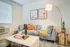 Cozy living room with a modern gray sofa accented by vibrant throw pillows, an elegant floor lamp, and stylish decor elements.
