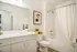 Modern bathroom featuring elegant fixtures, a sleek white countertop, and artistic wall decor for a sophisticated touch.