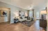 Modern living room boasting elegant decor, sleek wood flooring, and abundant natural light through large windows.