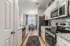 Modern kitchen with stainless steel appliances, elegant cabinetry, and inviting dining area with large window.
