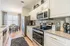 Bright and modern kitchen with stainless steel appliances, granite countertops, and elegant dining area overlooking large windows.