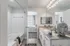 Elegant bathroom with dual sinks, stylish decor, and a modern bathtub, seamlessly connected to a cozy, well-lit bedroom.
