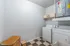 Bright and spacious laundry room featuring modern washer and dryer, sleek storage solutions, and checkerboard flooring for a stylish touch.