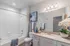 Elegant, bright bathroom with modern fixtures, featuring a sleek vanity, polished stone countertop, and vibrant decorative accents.