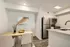 Modern apartment kitchen and dining area featuring sleek stainless steel appliances, cozy dining table with stylish decor, and elegant flooring.