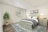 Bright and inviting bedroom with elegant decor, plush bedding, and a stylish potted plant.