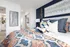 Bright and stylish bedroom with vibrant bedding, modern decor, and a serene blue accent wall.