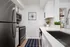 Sleek modern kitchen with stainless steel appliances, elegant white cabinetry, and bright natural accents.